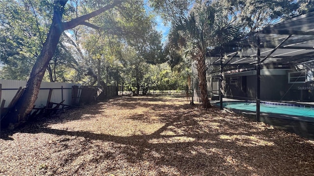 view of yard featuring a fenced backyard, a fenced in pool, and a lanai