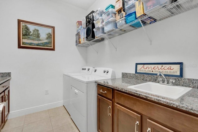 2312 Datura Loop, Saint Cloud, FL 34772 - clothes washing area with light tile patterned floors, a sink, baseboards, cabinet space, and washing machine and clothes dryer