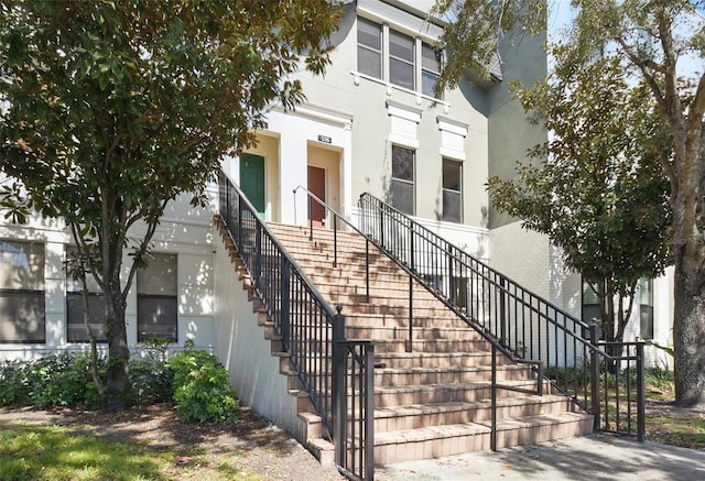 view of front of home featuring stucco siding and stairs