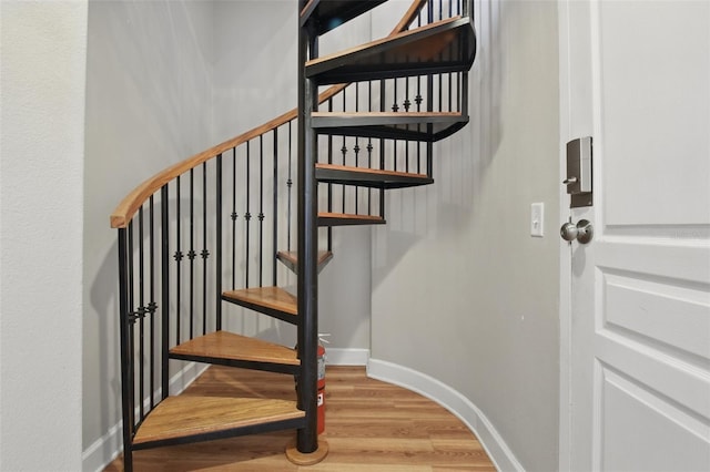 stairs with baseboards and wood finished floors