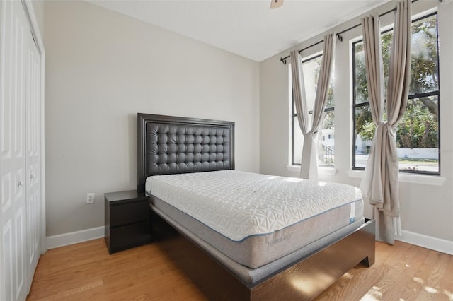 bedroom with baseboards, a closet, and light wood-style floors