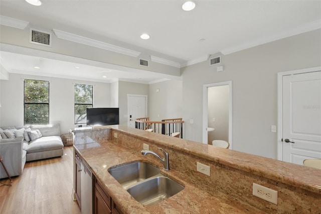 kitchen with open floor plan, a sink, visible vents, and crown molding