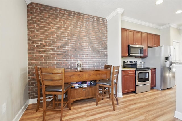 kitchen with brick wall, light wood-style flooring, appliances with stainless steel finishes, and ornamental molding