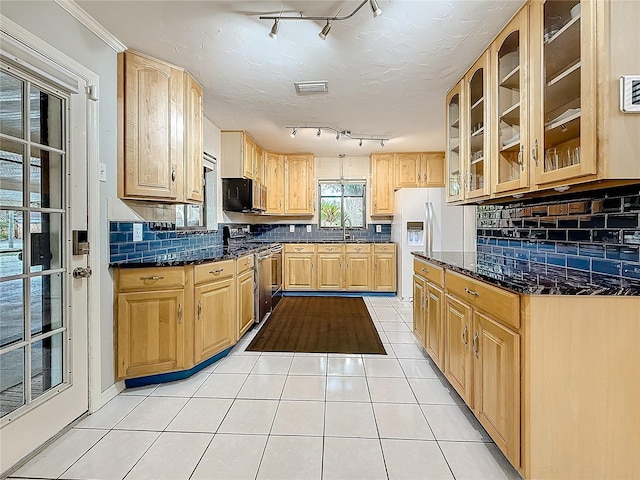 kitchen with black microwave, light tile patterned flooring, stainless steel stove, white refrigerator with ice dispenser, and glass insert cabinets