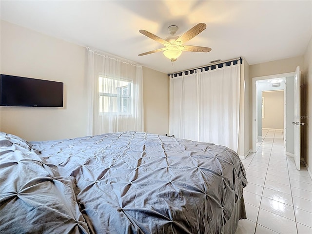 bedroom featuring ceiling fan, light tile patterned flooring, visible vents, and baseboards