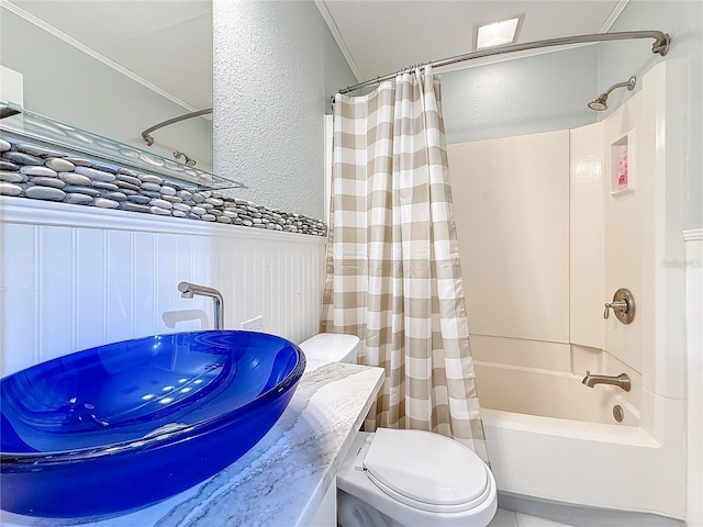 full bathroom featuring a textured wall, toilet, a wainscoted wall, vanity, and shower / tub combo with curtain