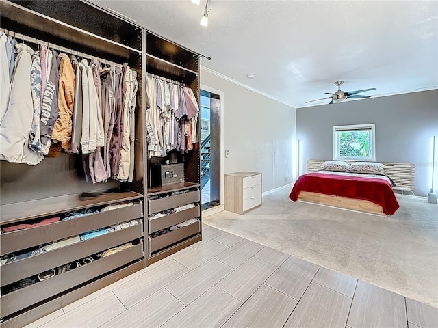 carpeted bedroom featuring ornamental molding, baseboards, and a ceiling fan