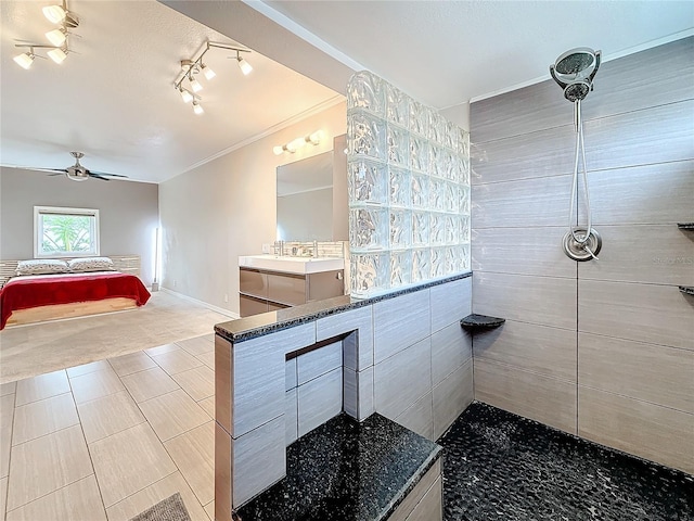 bathroom featuring ornamental molding, vanity, baseboards, and a walk in shower