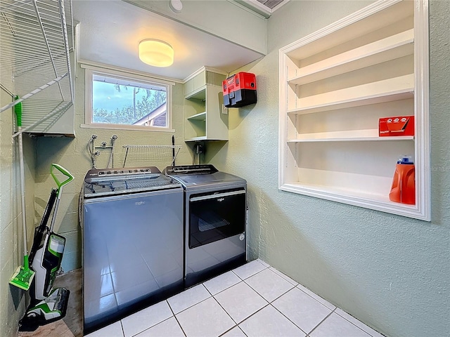 laundry room with a textured wall, laundry area, independent washer and dryer, and tile patterned floors