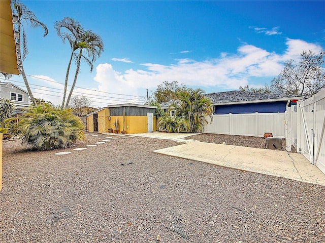 view of yard featuring an outbuilding, a patio area, and a fenced backyard