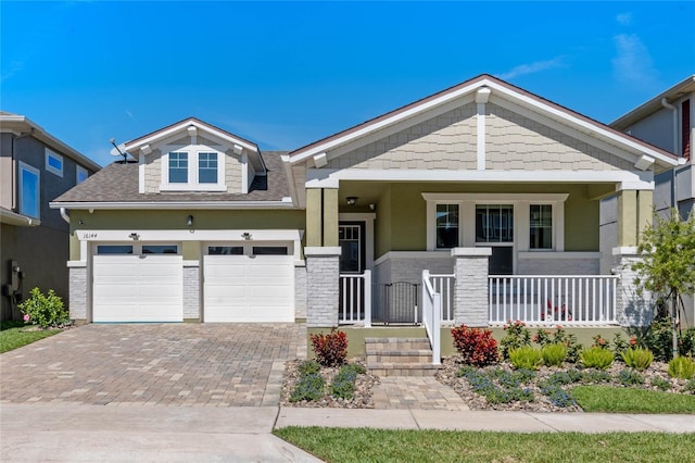 craftsman-style house with decorative driveway and covered porch