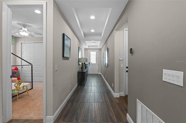 hall featuring visible vents, baseboards, wood finished floors, and recessed lighting