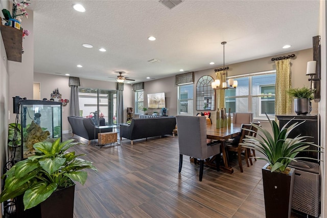 dining room featuring recessed lighting, visible vents, a textured ceiling, and ceiling fan with notable chandelier