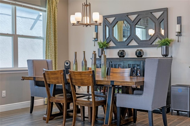 dining space featuring a chandelier, wood finished floors, and baseboards