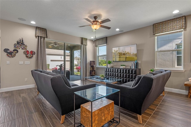 living room with baseboards, a ceiling fan, and wood finish floors