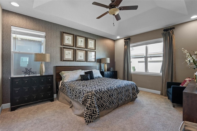 carpeted bedroom with wallpapered walls, baseboards, a raised ceiling, a ceiling fan, and recessed lighting