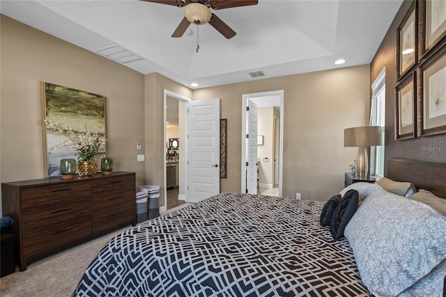 bedroom featuring light colored carpet, a raised ceiling, visible vents, and ceiling fan