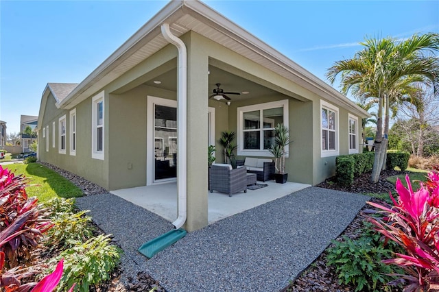 exterior space with a patio area, ceiling fan, outdoor lounge area, and stucco siding