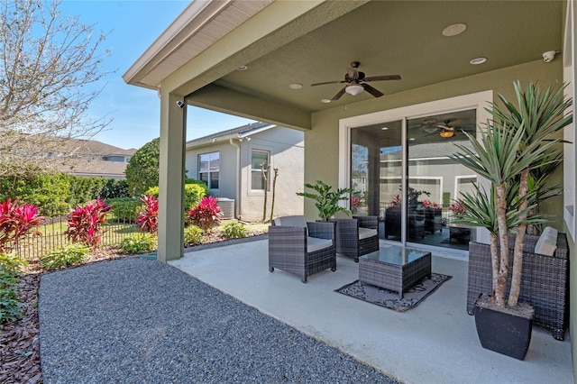 view of patio with fence, an outdoor hangout area, and a ceiling fan