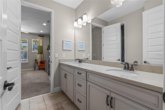 full bathroom featuring double vanity, a sink, baseboards, and tile patterned floors