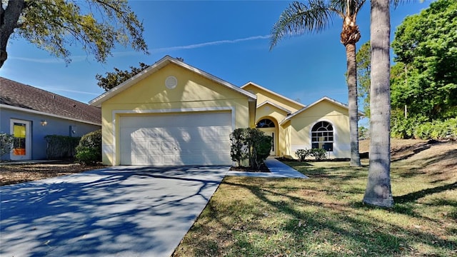 single story home with an attached garage, a front yard, concrete driveway, and stucco siding