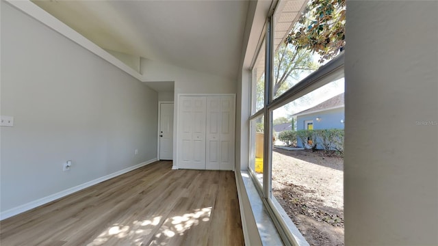 interior space with high vaulted ceiling, baseboards, and wood finished floors