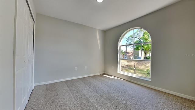 unfurnished room featuring carpet floors and baseboards