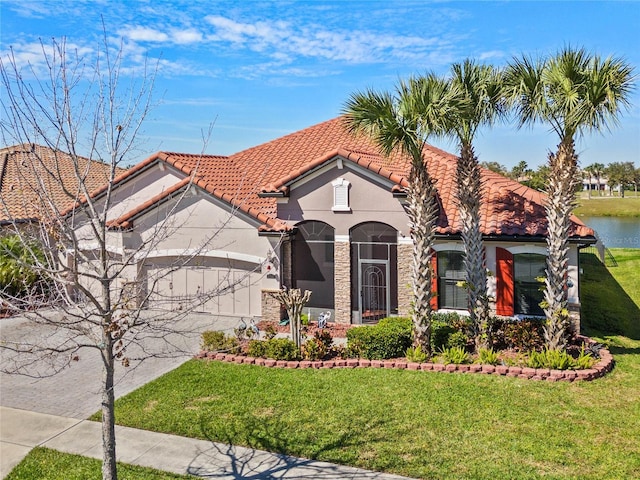 mediterranean / spanish home with driveway, a tile roof, an attached garage, a front yard, and stucco siding