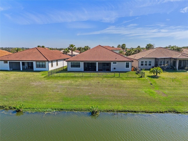 2541 Shoal Bass Way, Kissimmee, FL 34746 - back of house with a water view, a yard, a tiled roof, and a fenced backyard