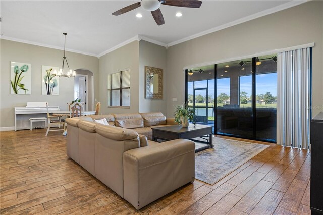 2541 Shoal Bass Way, Kissimmee, FL 34746 - living area with ornamental molding, a healthy amount of sunlight, light wood-type flooring, and ceiling fan with notable chandelier