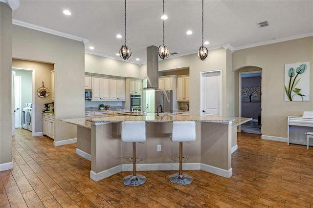 2541 Shoal Bass Way, Kissimmee, FL 34746 - kitchen featuring appliances with stainless steel finishes, crown molding, island range hood, arched walkways, and a large island with sink