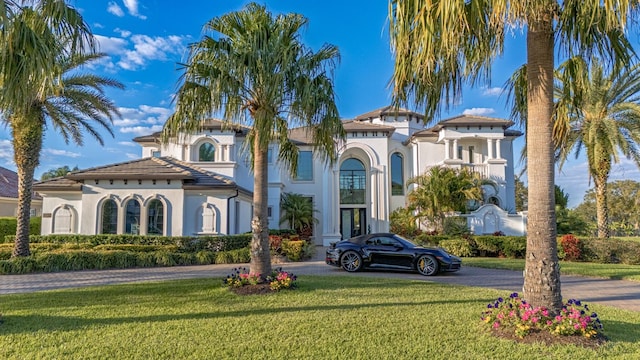 mediterranean / spanish home with a front lawn and stucco siding