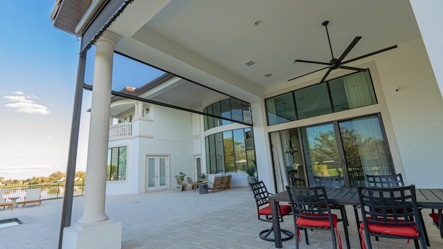 view of patio / terrace with french doors, a water view, outdoor dining space, and visible vents