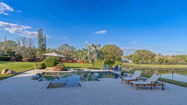 view of swimming pool featuring a patio, a water view, fence, a yard, and a pool with connected hot tub