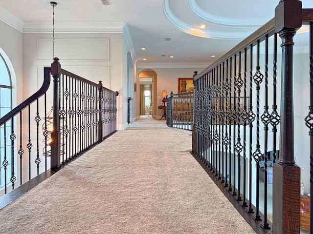 hallway featuring carpet floors, arched walkways, recessed lighting, visible vents, and ornamental molding