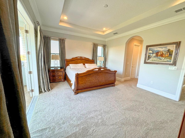 bedroom with arched walkways, baseboards, visible vents, and a tray ceiling