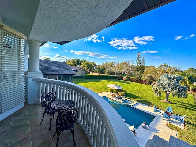 balcony featuring a pool with connected hot tub