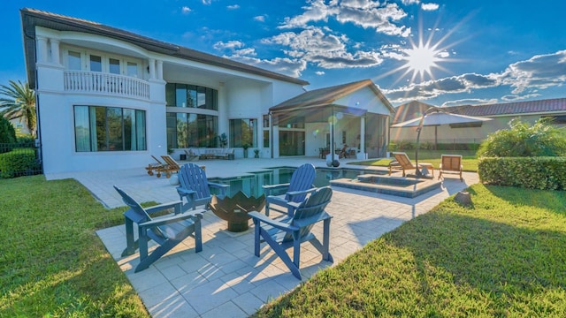 rear view of property featuring a patio area, an outdoor fire pit, fence, and a lawn