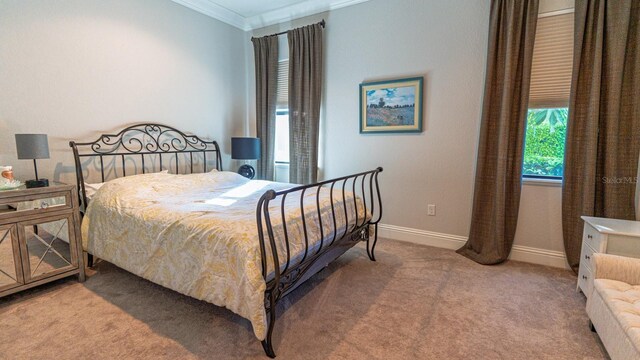 bedroom with ornamental molding, carpet, and baseboards