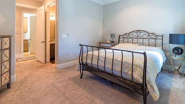 bedroom with ensuite bathroom, crown molding, carpet, and baseboards