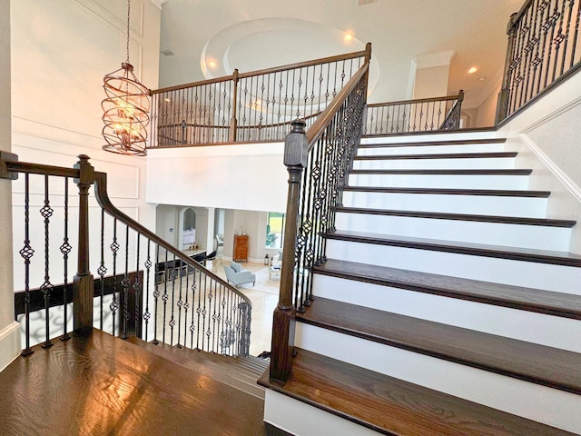 stairs with a high ceiling and a notable chandelier