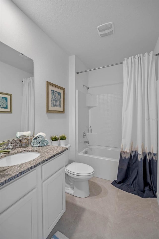 full bath featuring visible vents, toilet, shower / bath combo with shower curtain, a textured ceiling, and vanity