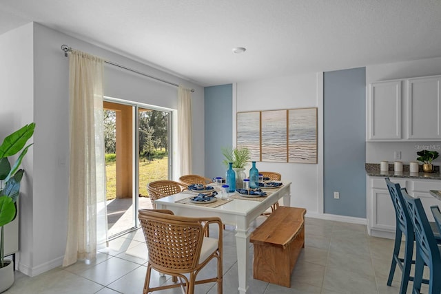 dining space with light tile patterned floors and baseboards