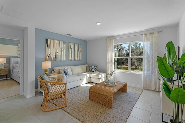 living room with baseboards, visible vents, and tile patterned floors