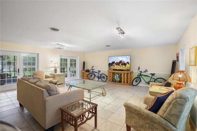 living area featuring light tile patterned floors, visible vents, french doors, and a textured ceiling