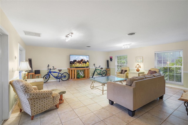 living area featuring light tile patterned flooring and visible vents