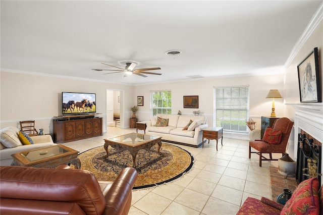 living area with visible vents, ornamental molding, a fireplace, light tile patterned flooring, and a ceiling fan