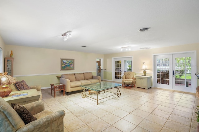 living area featuring light tile patterned floors, french doors, and visible vents