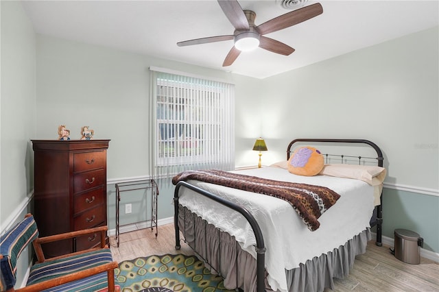 bedroom featuring a ceiling fan, wood finished floors, and baseboards