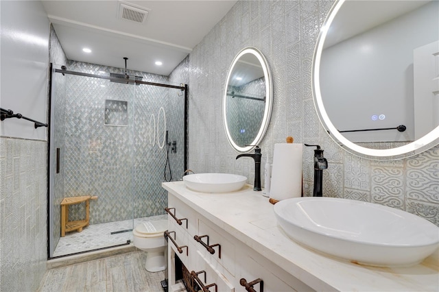 full bathroom with a sink, visible vents, toilet, and a shower stall